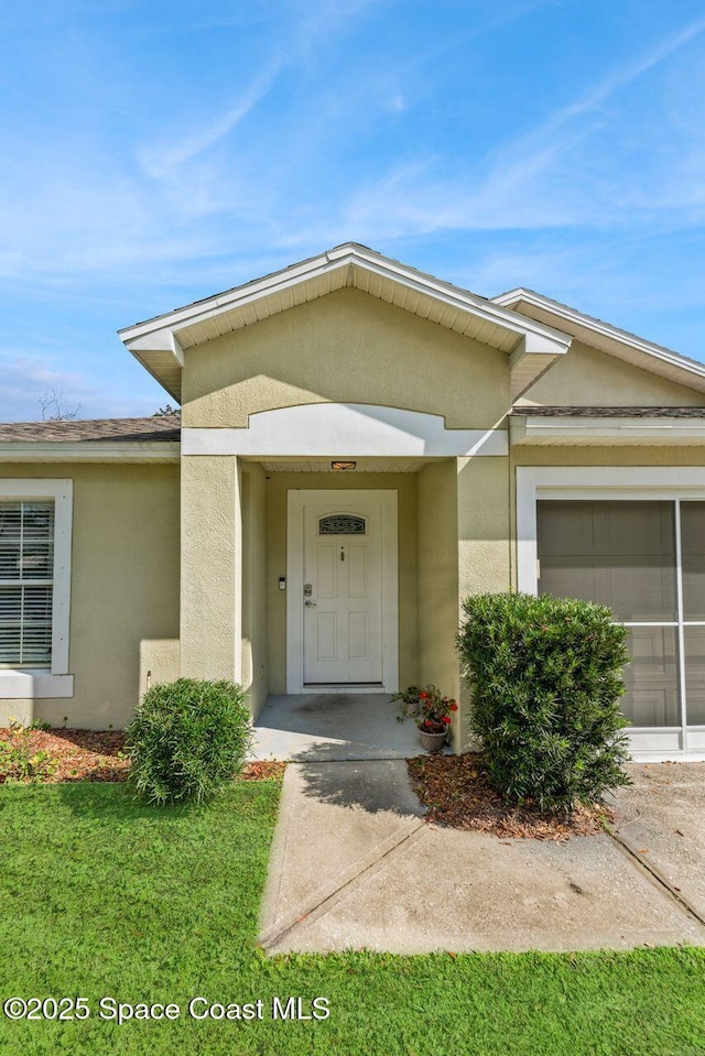 property entrance featuring a garage and a yard