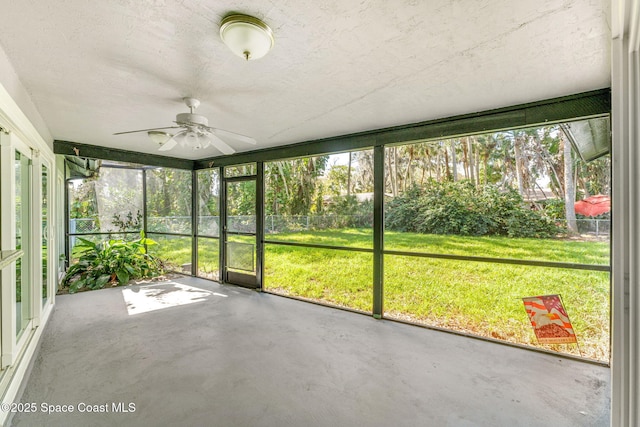 unfurnished sunroom featuring ceiling fan and a wealth of natural light