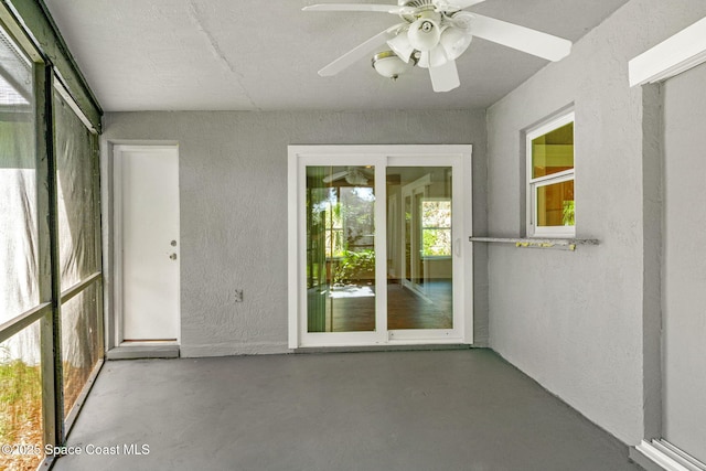 unfurnished sunroom featuring ceiling fan