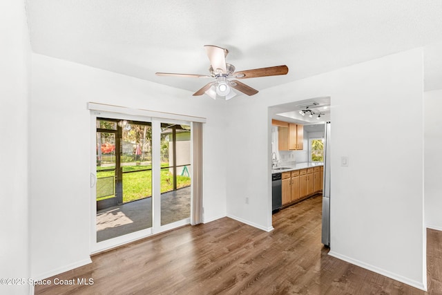 interior space featuring ceiling fan, a healthy amount of sunlight, dark wood-type flooring, and sink