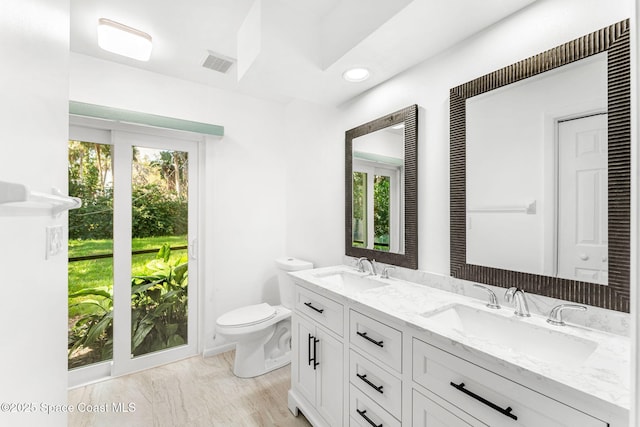 bathroom featuring plenty of natural light, vanity, and toilet