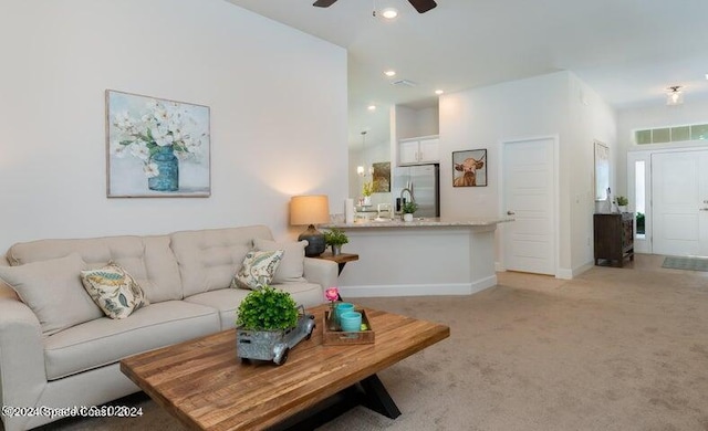 carpeted living room with ceiling fan