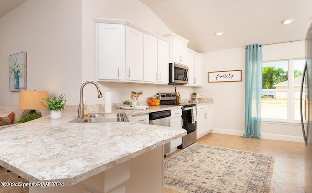 kitchen featuring white cabinetry, sink, kitchen peninsula, lofted ceiling, and appliances with stainless steel finishes