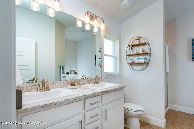 bathroom with tile patterned floors, vanity, a shower with shower door, and toilet