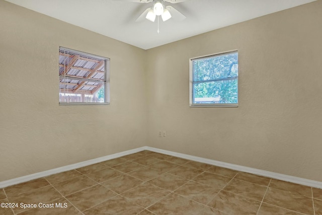 empty room with ceiling fan and light tile patterned floors