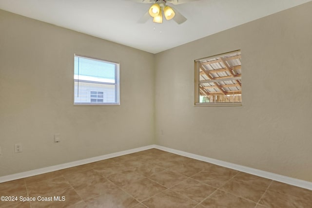 empty room with ceiling fan and light tile patterned floors