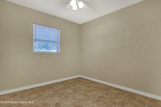 tiled spare room with ceiling fan