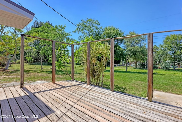 wooden deck featuring a lawn