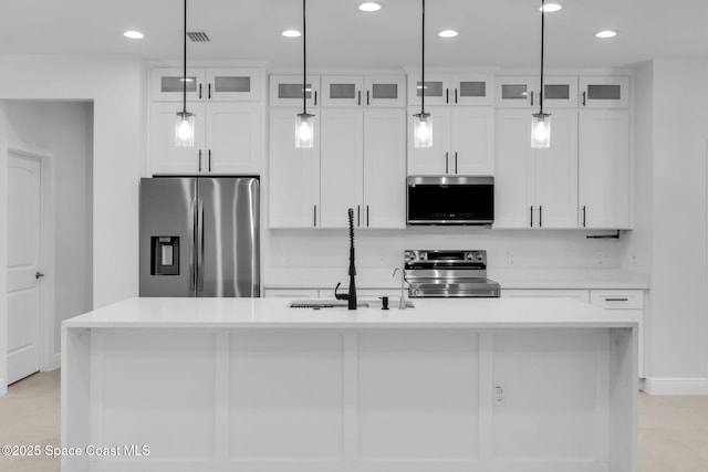 kitchen featuring sink, white cabinets, a center island with sink, and stainless steel appliances