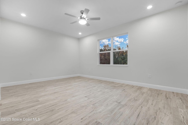 empty room with ceiling fan and light hardwood / wood-style flooring