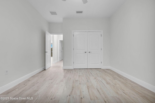 unfurnished bedroom with ceiling fan, a closet, and light hardwood / wood-style flooring