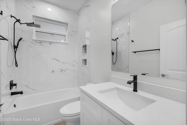 full bathroom featuring tiled shower / bath combo, vanity, and toilet