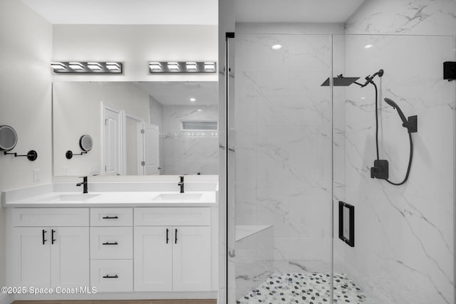 bathroom featuring a shower with shower door and vanity