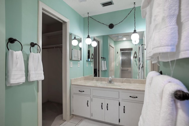 bathroom featuring tile patterned floors, vanity, and a textured ceiling