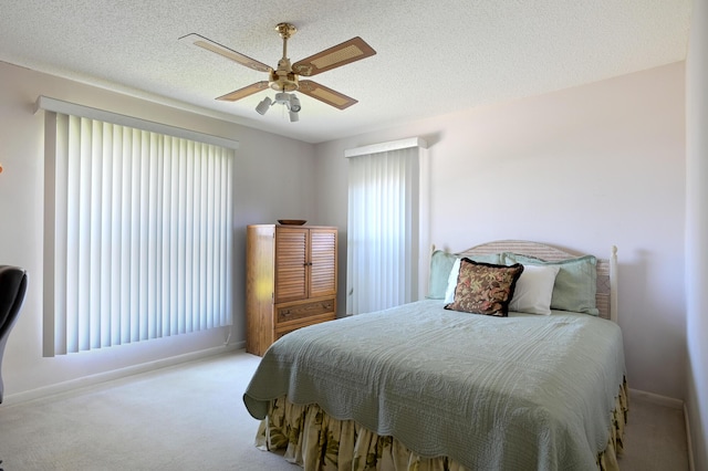 carpeted bedroom with a textured ceiling and ceiling fan