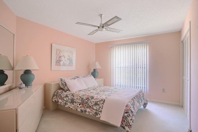 carpeted bedroom with a textured ceiling, a closet, and ceiling fan