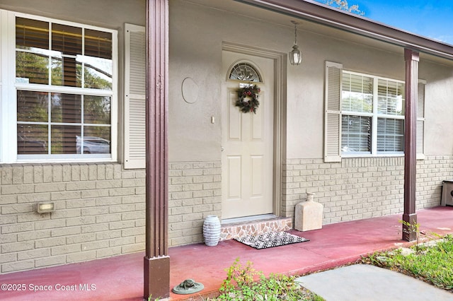 view of exterior entry featuring covered porch