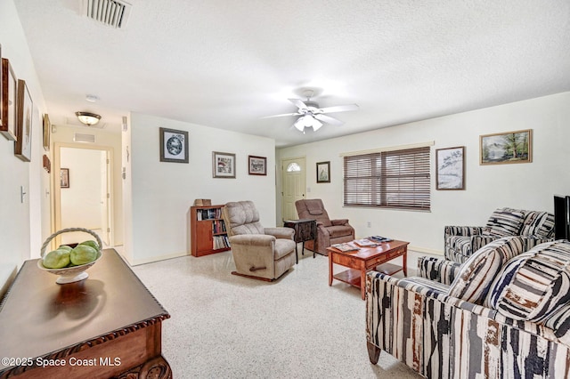 living room with a textured ceiling and ceiling fan