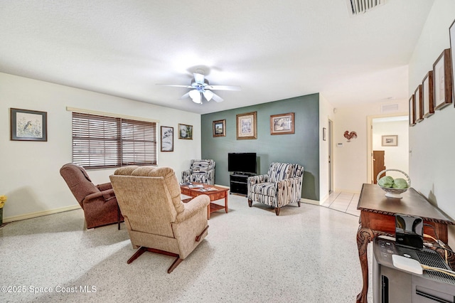 living room with a textured ceiling and ceiling fan