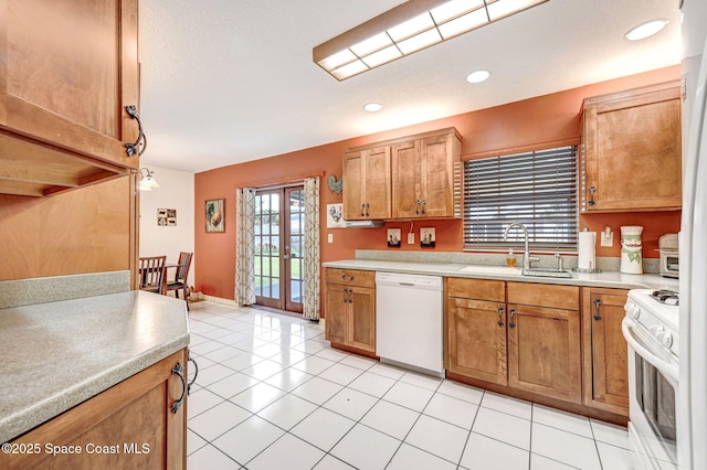 kitchen with light tile patterned floors, white appliances, and sink