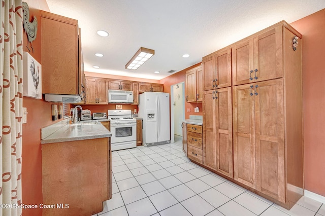 kitchen with sink, light tile patterned floors, and white appliances