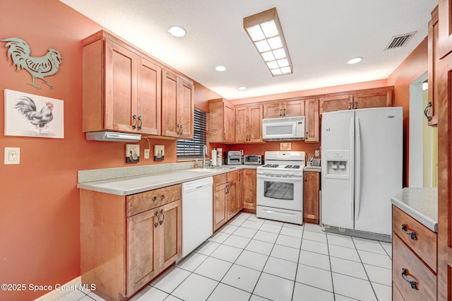 kitchen with light tile patterned flooring, white appliances, and sink