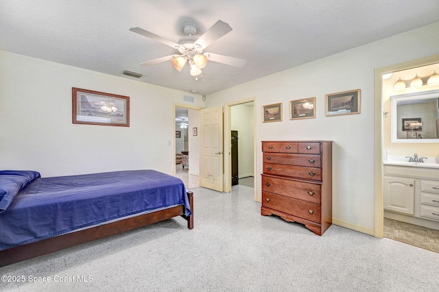 bedroom featuring a textured ceiling, ensuite bathroom, ceiling fan, and sink