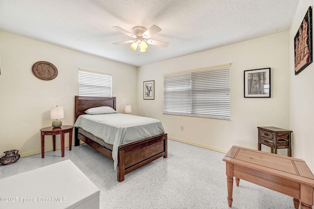 bedroom with ceiling fan and a textured ceiling