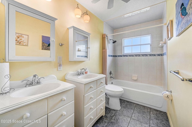 full bathroom featuring vanity, tiled shower / bath, tile patterned flooring, ceiling fan, and toilet