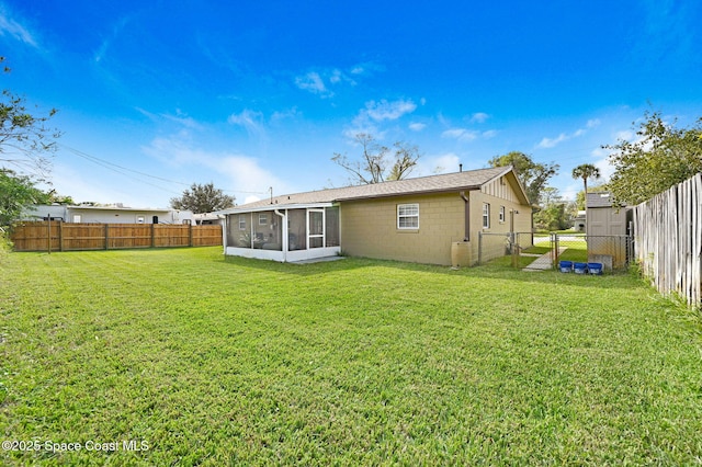 rear view of house featuring a sunroom and a yard