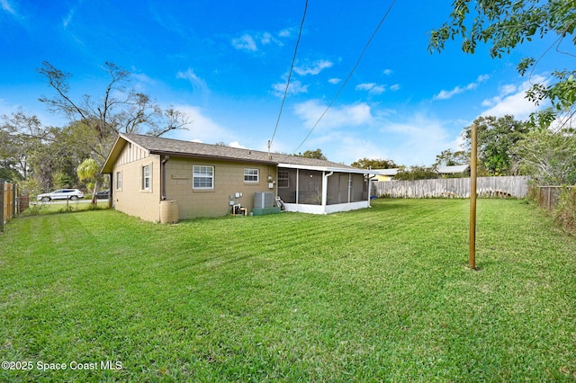 rear view of house with a sunroom and a yard