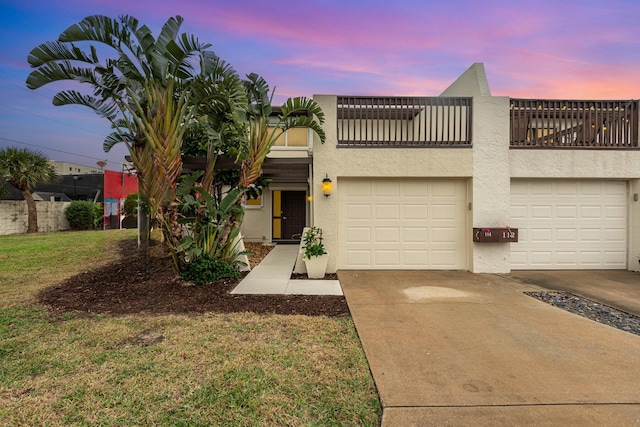 view of front of property featuring a yard and a balcony