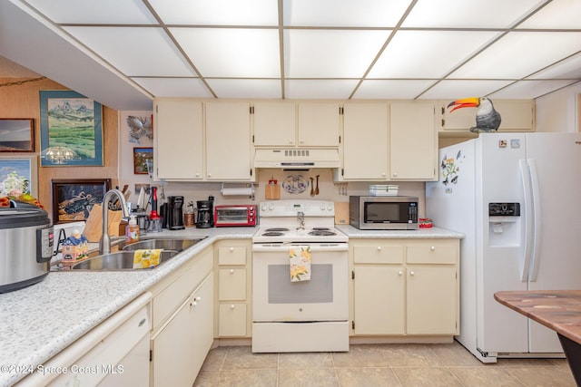 kitchen featuring white appliances, sink, light tile patterned floors, and cream cabinets