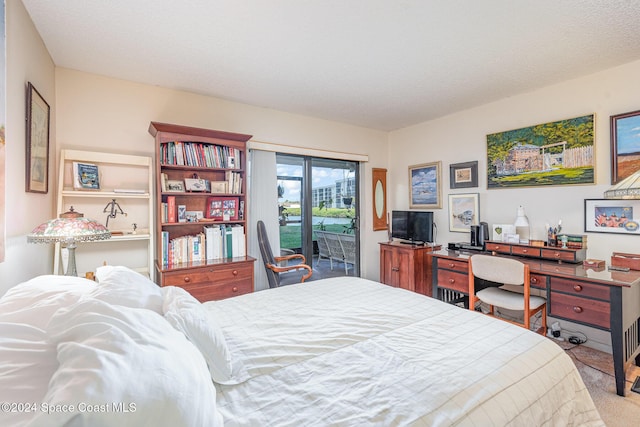 carpeted bedroom featuring a textured ceiling and access to outside