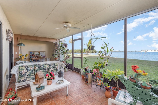 sunroom with a water view and ceiling fan