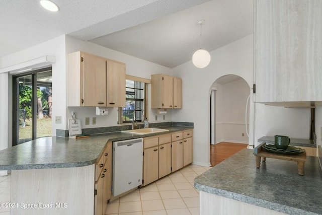 kitchen with light brown cabinetry, white dishwasher, lofted ceiling, and sink