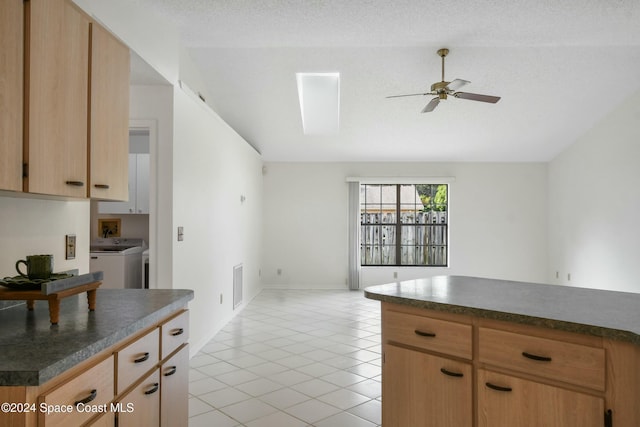 kitchen with washing machine and clothes dryer, ceiling fan, light brown cabinets, a textured ceiling, and light tile patterned floors