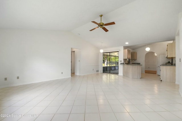 unfurnished living room featuring ceiling fan, light tile patterned floors, sink, and high vaulted ceiling