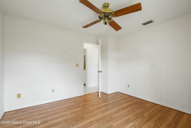 empty room with ceiling fan and light hardwood / wood-style flooring