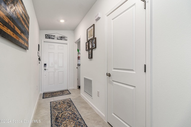 doorway with light tile patterned flooring