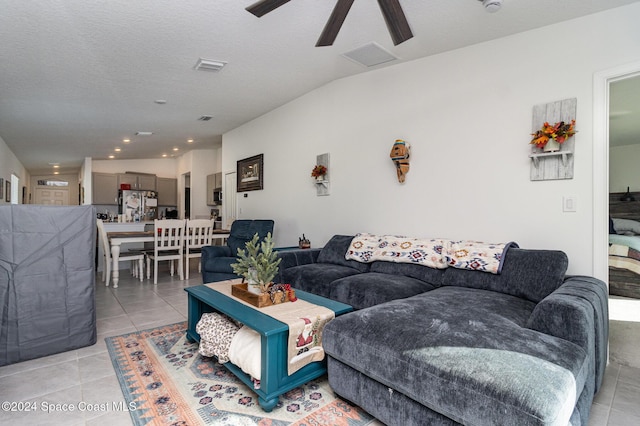 living room with light tile patterned floors, a textured ceiling, ceiling fan, and lofted ceiling