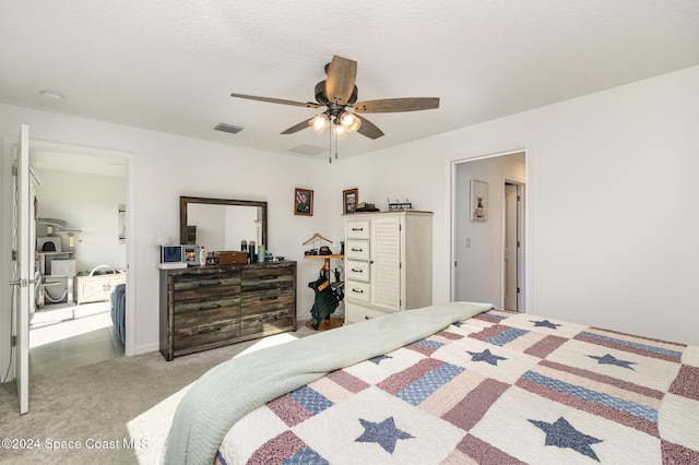 carpeted bedroom featuring ceiling fan and a textured ceiling