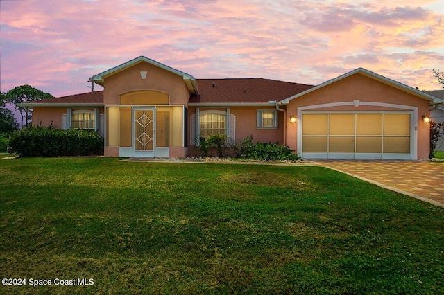 ranch-style house featuring a yard and a garage