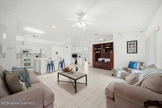 living room featuring light tile patterned floors, a textured ceiling, ceiling fan, and lofted ceiling