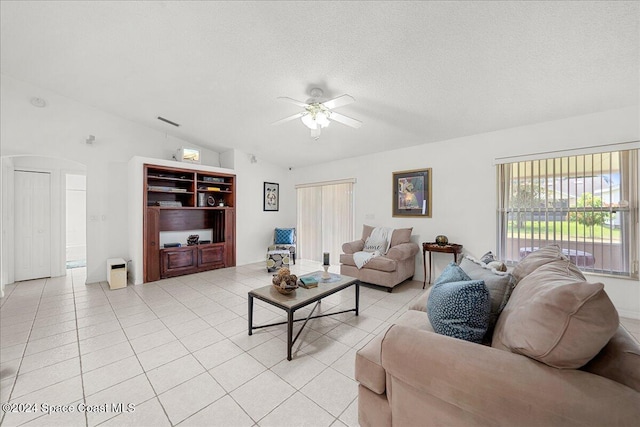 tiled living room featuring a textured ceiling, vaulted ceiling, and ceiling fan