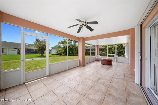 unfurnished sunroom featuring ceiling fan