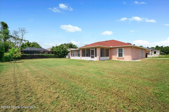 back of house featuring a sunroom and a yard