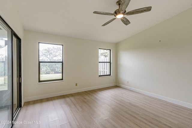 empty room with ceiling fan, light hardwood / wood-style floors, and lofted ceiling