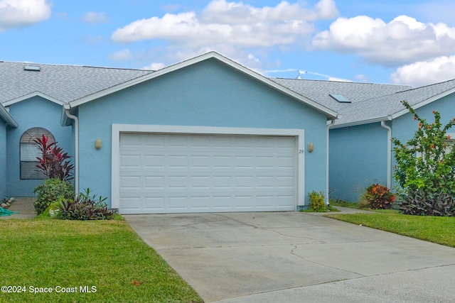 single story home featuring a front yard and a garage