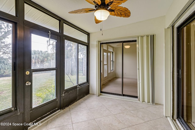 unfurnished sunroom featuring ceiling fan